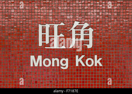 Sign of Mong Kok MTR (subway/metro) station in Hong Kong, China, written in Chinese and English on small red tile wall. Stock Photo