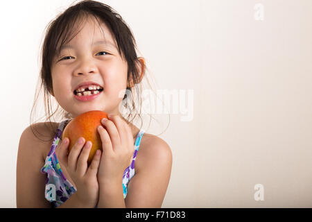 Child is holding an apple in her hands background. Stock Photo