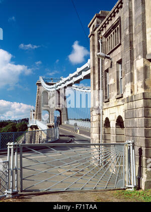 The Menai Suspension Bridge from street level, including an original iron, crossing sun-rays gate designed by Thomas Telford. Stock Photo