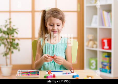 Kid playing modeling plasticine or molding clay Stock Photo