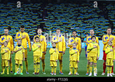 KYIV, UKRAINE - NOVEMBER 15, 2013: Ukraine National football team players and unidentified young footballers listen the national Stock Photo