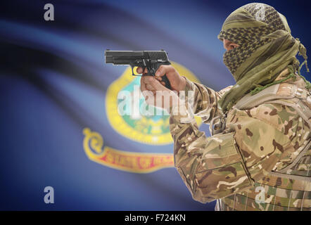 Male in muslim keffiyeh with gun in hand and flag on background series - Idaho Stock Photo