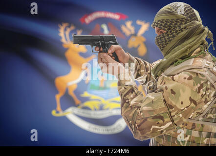 Male in muslim keffiyeh with gun in hand and flag on background series - Michigan Stock Photo