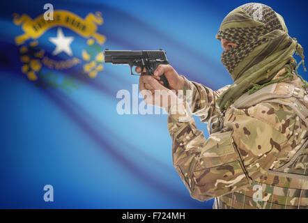 Male in muslim keffiyeh with gun in hand and flag on background series - Nevada Stock Photo