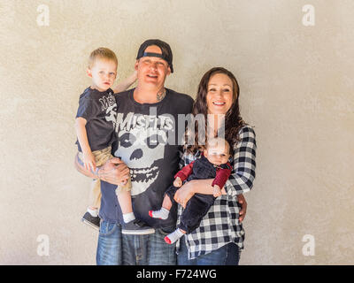 Portrait of a millennial generation family with two children and tattooed father standing together in Chico, California. Stock Photo