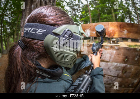 A paintball player girl at work. Jeune fille joueuse de paintball en action. Stock Photo