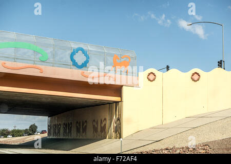 decorative elements on pale yellow walls of Arizona highway overpass are painted in southwestern colors umber terra cotta green Stock Photo