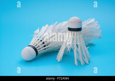 two used shuttlecocks on a blue background Stock Photo