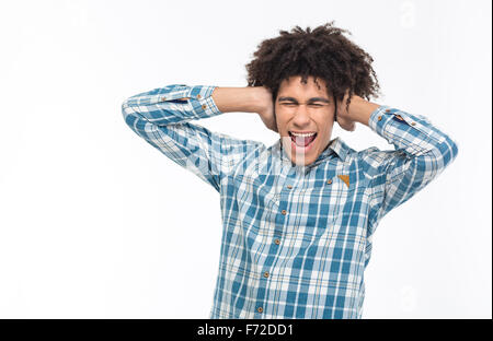 Portrait of a young afro american man covering his ears and screaming isolated on a white background Stock Photo