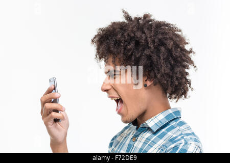 Side view portrait of afro amerian man screaming on smartphone isolated on a white background Stock Photo