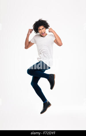 Full length portrait of a cheerful afro american man jumping isolated on a white background Stock Photo