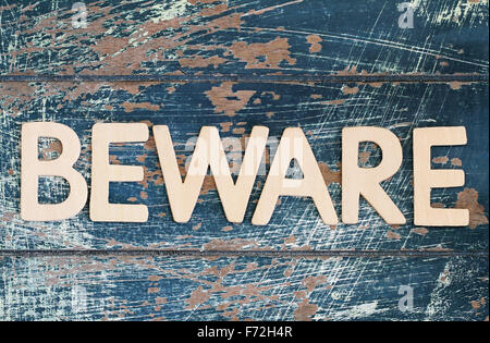 Word beware written with wooden letters on rustic surface Stock Photo