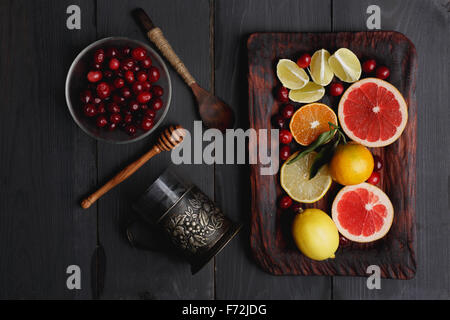 Ingredients for hot winter punch,sangria,toddy or mulled wine. Sliced lemon, grapefruit,tangerine, lime and cranberry on a rusti Stock Photo