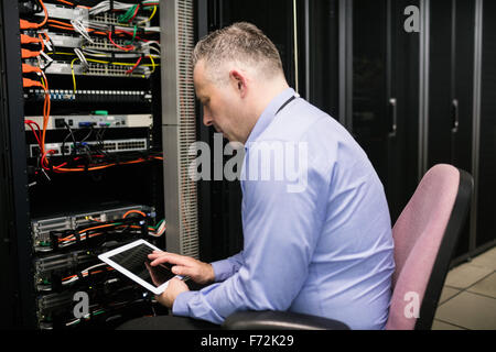 Technician using tablet in server room Stock Photo