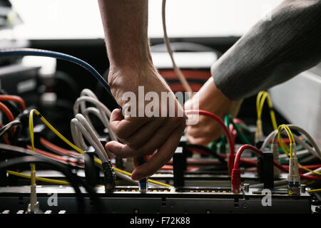 Team of technicians working together on servers Stock Photo