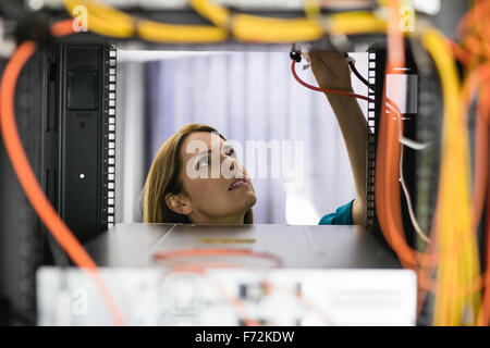 Technician looking at open server locker Stock Photo