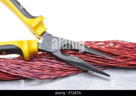 Pliers tools and cables on metal surface with white background and place for text Stock Photo