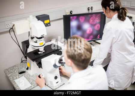 Scientist looking through a microscope Stock Photo