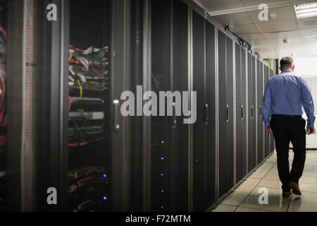 Technician walking in server hallway Stock Photo