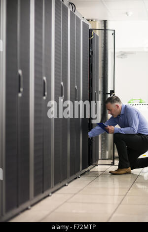 Technician looking at open server locker Stock Photo