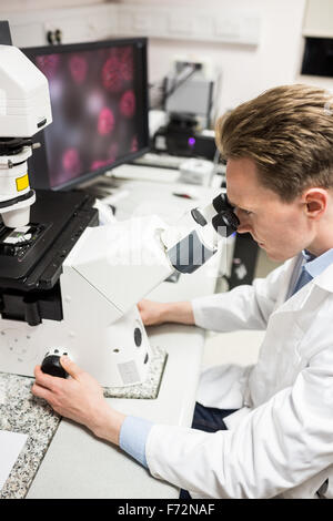 Scientist looking through a microscope Stock Photo