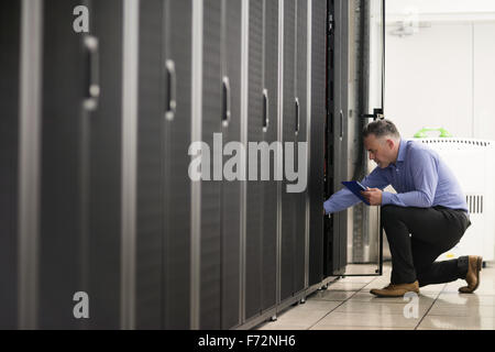 Technician looking at open server locker Stock Photo