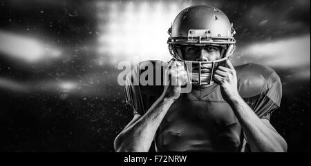 Composite image of portrait of american football player holding helmet Stock Photo