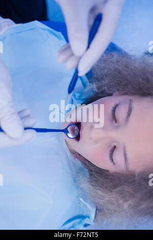 Pediatric dentist using dental explorer and angled mirror Stock Photo