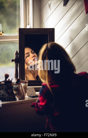 Woman making up herself in front of the mirror Stock Photo