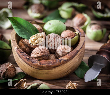 Walnuts in the wooden bowl on the table. Stock Photo
