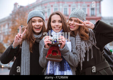 Portrait of a young girlfriends standing with photo camera outdoors Stock Photo