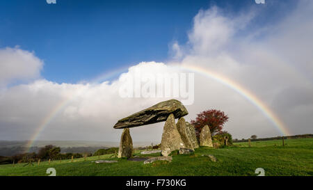 Pentre Ifan, the largest and best preserved neolithic dolmen in Wales, under a rainbow, with blue sky and clouds. Mystical scheduled ancient monument. Stock Photo