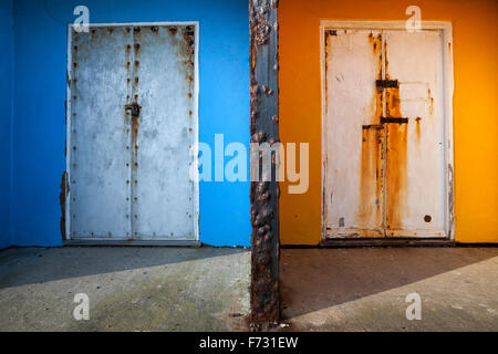 Rusted doors to brightly painted beach chalets at Bexhill on Sea, East Sussex, England, UK Stock Photo