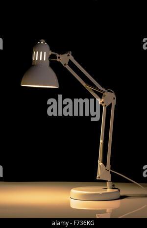 Angle poise lamp on black background. Stock Photo