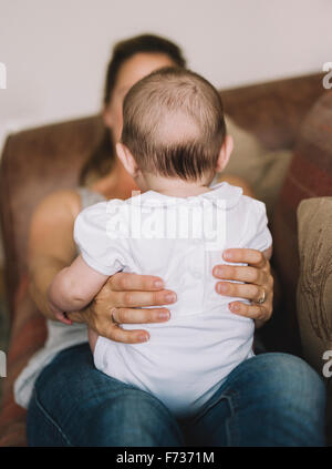 A woman holding a baby girl on her knee. Stock Photo
