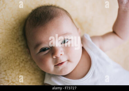A baby girl lying on her back looking upwards. Stock Photo