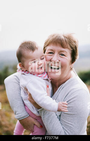 A woman holding a young baby close to her and laughing. Stock Photo