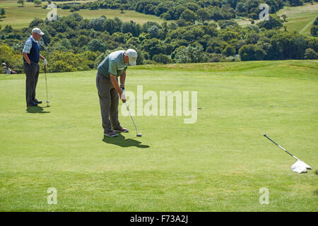 Senior golfers playing at Pyecombe Golf Club,  West Sussex England United Kingdom UK Stock Photo