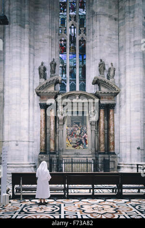 A nun examines the interior of the Milan Duomo Cathedral. Stock Photo