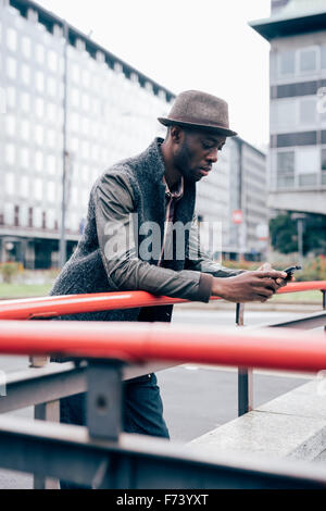 Knee figure of young handsome afro black man leaning on a handrail ...