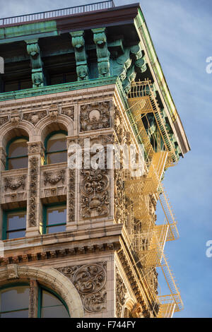 Late 19th century building facade in Soho, Manhattan, New York City. Terra cotta ornaments, copper cornice and fire escape. Stock Photo