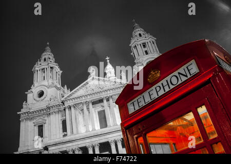 St Paul's Cathedral at night with traditional K6 red telephone box  London England UK red on black and white monochrome