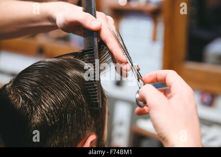 Back view of unrecognizable male making haircut to guy using scissors  against blurred interior of light bathroom at home Stock Photo - Alamy