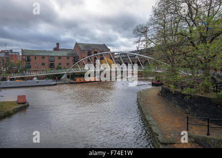 Footbridge spanning the Rochdale canal in Castlefield, Manchester with metal railings on either side. Stock Photo