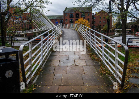 Footbridge spanning the Rochdale canal in Castlefield, Manchester with metal railings on either side. Stock Photo