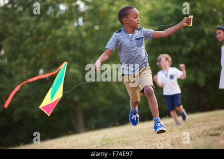 African kid having fun flying a kite in the nature Stock Photo