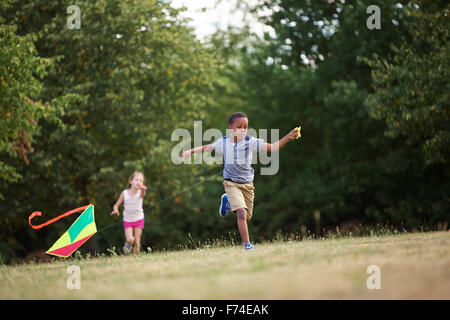 Girl and boy flying a kite in summer Stock Photo