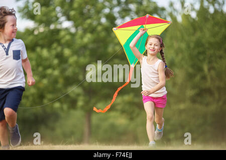 Girl and boy flying a kite and havin fun Stock Photo