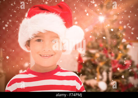 Composite image of cute little boy in santa hat Stock Photo