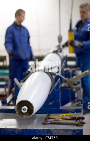 HANDOUT - A handout picture made available on 25 November 2015 by the German armed forces (Bundeswehr) shows employees of the company Nammo Buck GmbH working on the munition of a M26 MLRS multiple missile launcher in Pinnow, Germany, 25 November 2015. Some 25 years after the end of the Cold War, the last batch of cluster munition of the German armed forces has been dismantled. Employees of a munitions disposal company disassembled the remaining missiles in Pinnow. Photo: JANA NEUMANN/Bundeswehr (ATTENTION EDITORS: FOR EDITORIAL USE ONLY IN CONNECTION WITH CURRENT REPORTING/ MANDATORY CREDIT Stock Photo